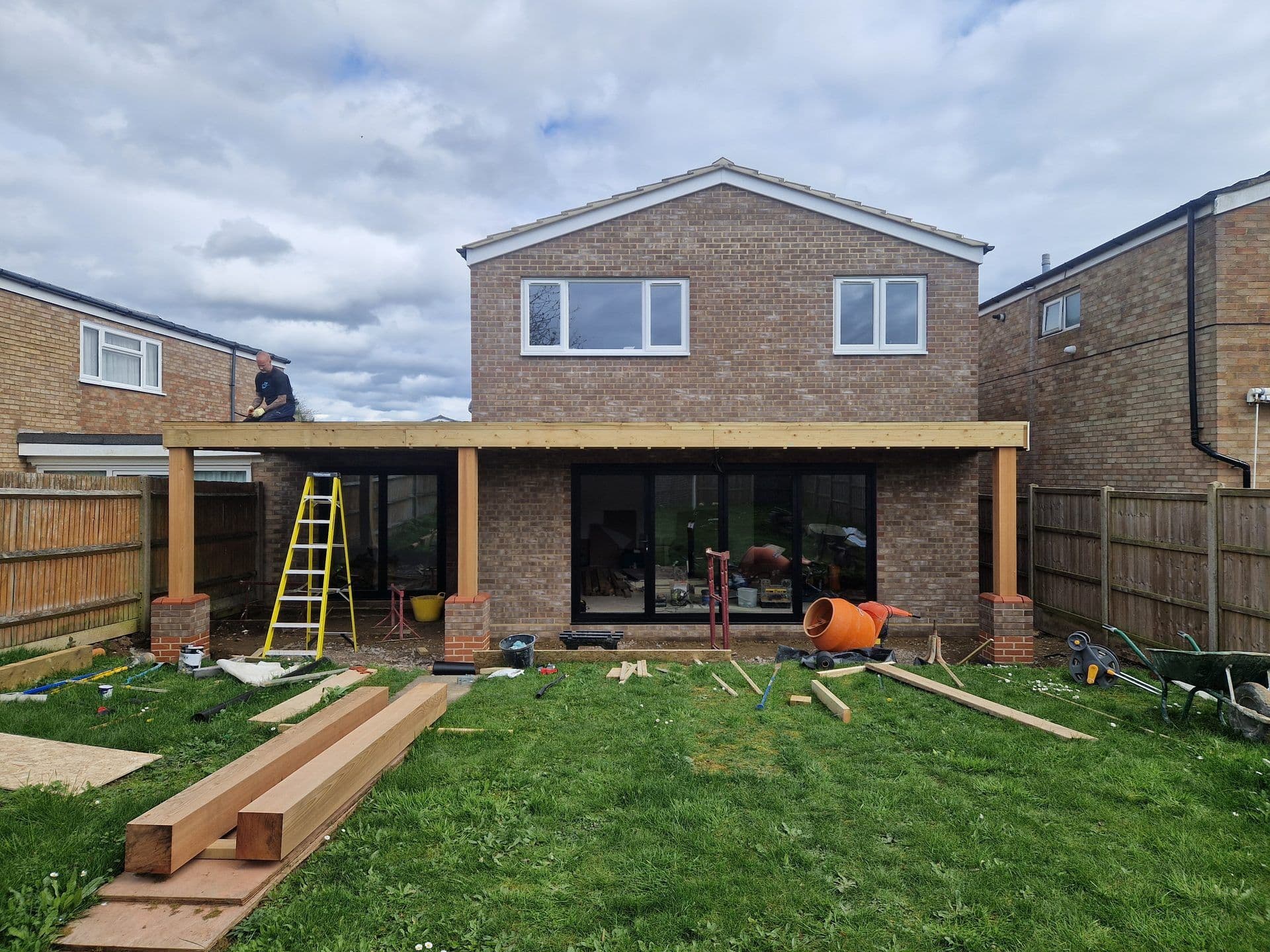 Timber beam and flat roof structure going up on a rear extension by DNR Build