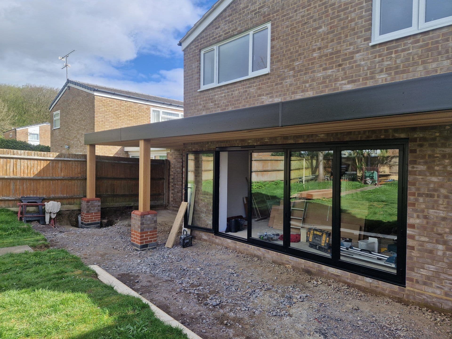 Side view of a rear extension with bi-fold doors and flat roof nearing completion by DNR Build